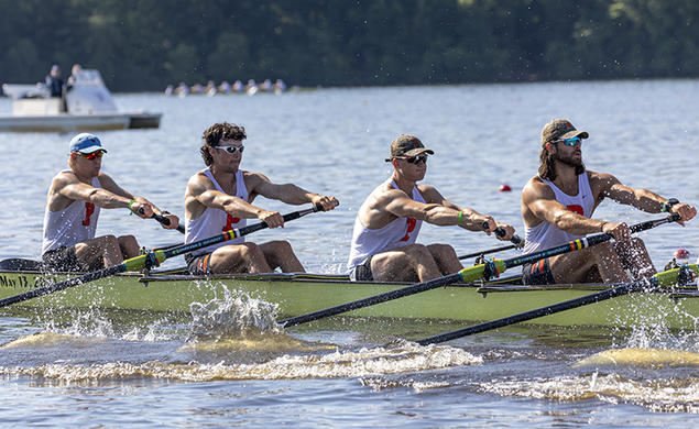 Four rowers from an eight man boat in action at a rowing regatta