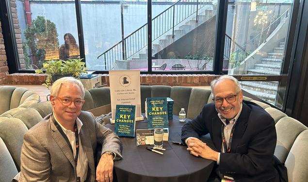 Photo of Bill Rosenblatt and Howie Singer sitting around a table with their book "Key Changes"