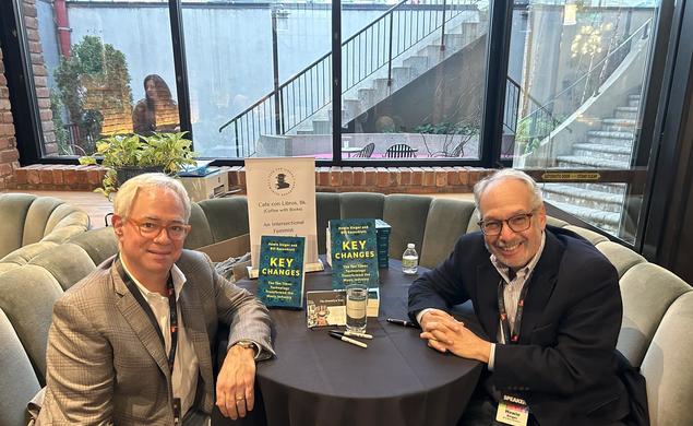 Photo of Bill Rosenblatt and Howie Singer sitting around a table with their book "Key Changes"