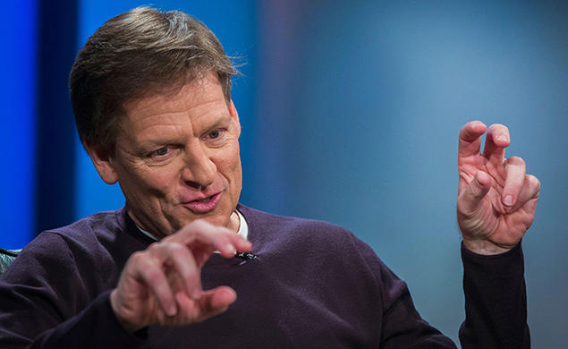 This is a photo of author Michael Lewis ’82 gesturing with his hands while he speaks during a 2014 interview at Reuters about his book “Flash Boys,” about high-frequency trading. 
