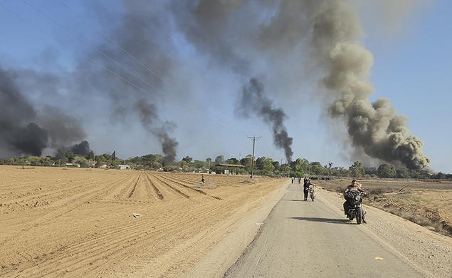 Palestinians walk away from a kibbutz, near the border fence with the Gaza Strip, while carrying out a deadly cross-border attack in southern Israel on Oct. 7, 2023.