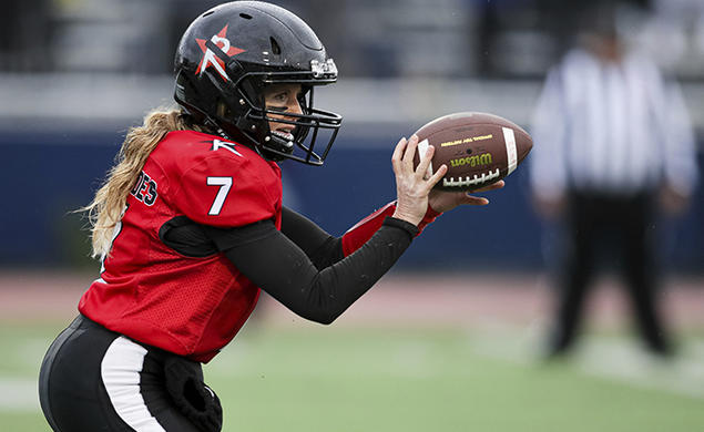 Boston Renegades quarterback Allison Cahill ’03 dishes the football to a running back in a game between the Boston Renegades and the Tampa Bay Inferno on June 3.
