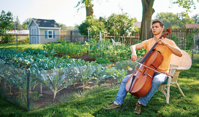 With his eyes shut, Calvin Van Zytveld ’19 plays a cello outdoors, a garden and a shed in the background.