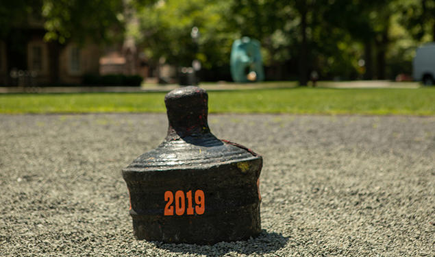 The back of a buried cannon is visible with "2019" written on it in orange.