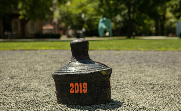 The back of a buried cannon is visible with "2019" written on it in orange.