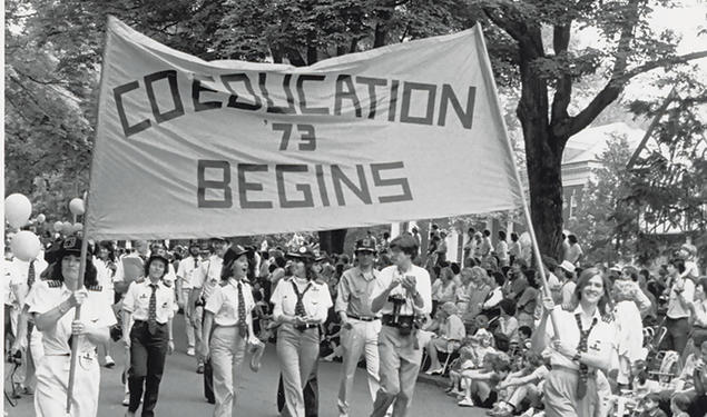 The Class of ’73 marches proudly with the “Coeducation Begins” banner at Reunions in 1983.