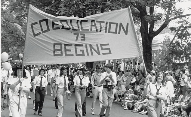 The Class of ’73 marches proudly with the “Coeducation Begins” banner at Reunions in 1983.