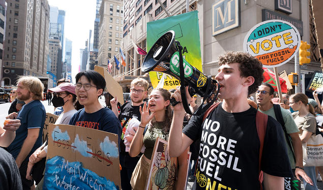 Princeton students on a street in New York City holding signs and bullhorn while marching