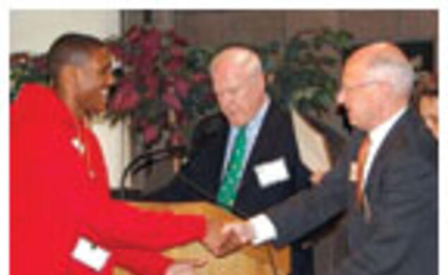 Henry Von Kohorn '66, second from right, assisted by Brian Breuel '66 and Marguerite Vera '79, recognize Princeton Prize winner Sidney Johnson during a race-relations symposium on campus.