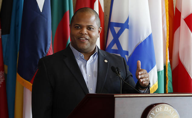 Dallas Mayor Eric Johnson *03 speaks at a podium.