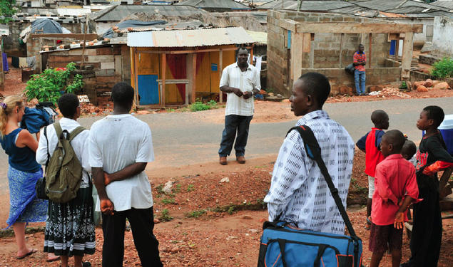 Professor Carolyn Rouse (second from left) documents elder Jacob Otabil’s tour of Oshiyie, Ghana, site of the school she is building. She notes that “what looks like poverty and suffering to some is challenged by Otabil’s description of a vibrant co