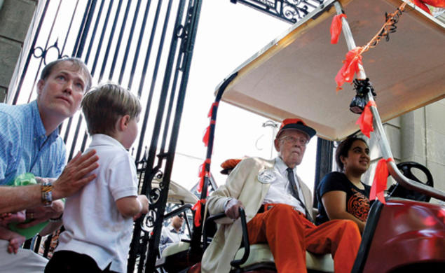 Riding in his golf cart at the P-rade in 2011, Warnock passes PAW writer W. Barksdale Maynard ’88 and his son, Alexander. 