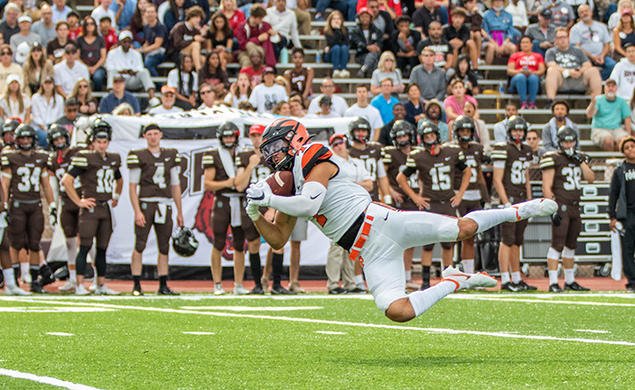 Wide receiver Dylan Classi ’23 dives sideways to catch the ball.