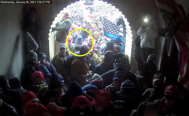 Giberson_sentencing2.jpg The view out of a crowded Capitol entrance tunnel; a yellow circle highlights Giberson facing the entrance wearing a blue baseball cap and a gaiter over his face.