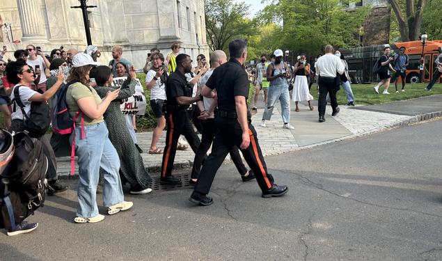 Two protesters are arrested by Public Safety officers and loaded onto a bus during the occupation of Clio Hall on April 29.