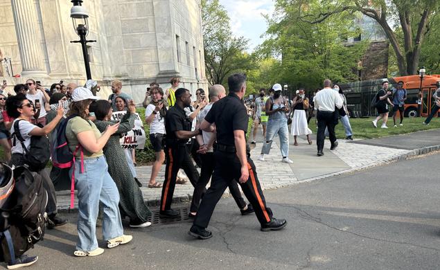 Two protesters are arrested by Public Safety officers and loaded onto a bus during the occupation of Clio Hall on April 29.