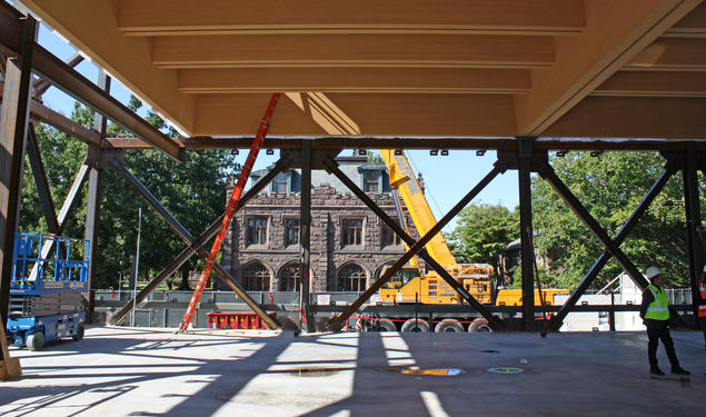 A Gothic Princeton building is visible through the framed-out construction of the art museum. A large piece of construction equipment is in the middle.