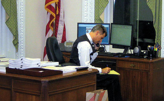 Dressed for a White House party, Alan Krueger works on statistics needed for a 2011 presidential speech.