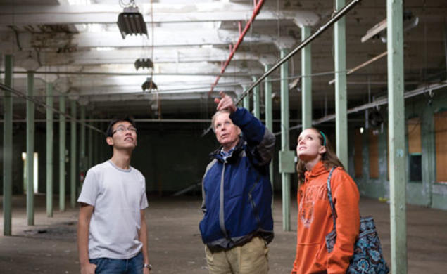 Visiting lecturer Robert Harris, center, and seniors Eric Hui and Emily Weissinger discuss the renovation of a vacant factory.