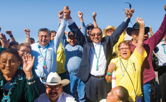 Rex Lee Jim ’86, center, joins hands with Navajo Nation presidential candidate Ben Shelly at a campaign stop in September at the Southwest Navajo Fair in Dilkon, Ariz.