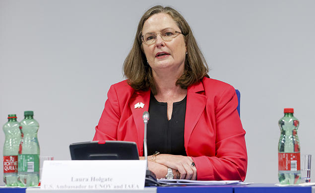 This is a photo of Laura Colgate sitting at a table and talking.