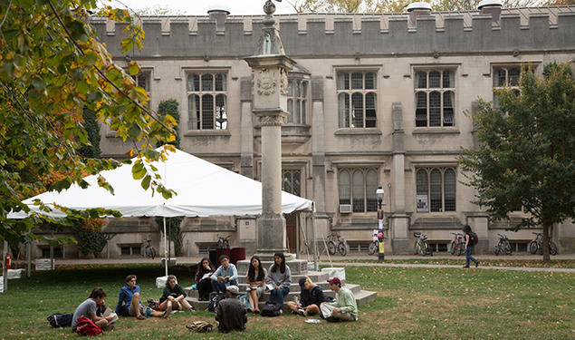 Students sit on the steps and on the ground at the base of the Mather Sundial.