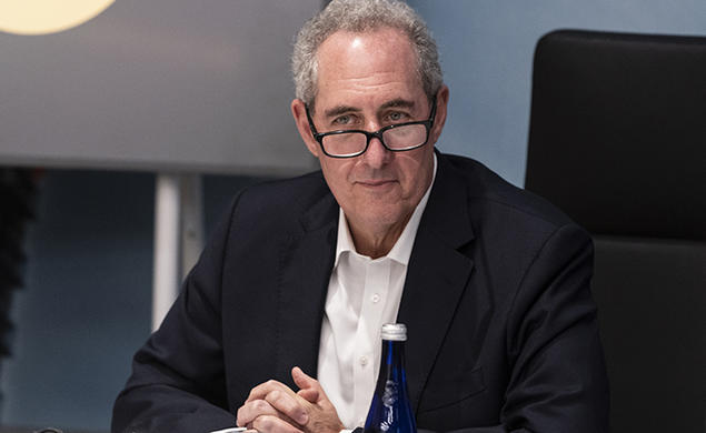 Michael Froman ’85 folds his hands while sitting at a table.