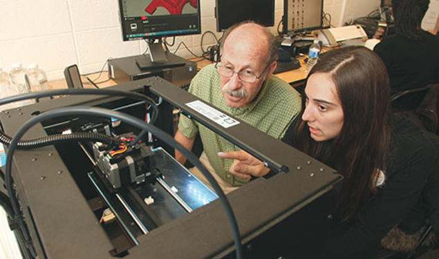 Professor Michael Littman and Cara de Freitas Bart ’15 review the results of a 3-D printing test.