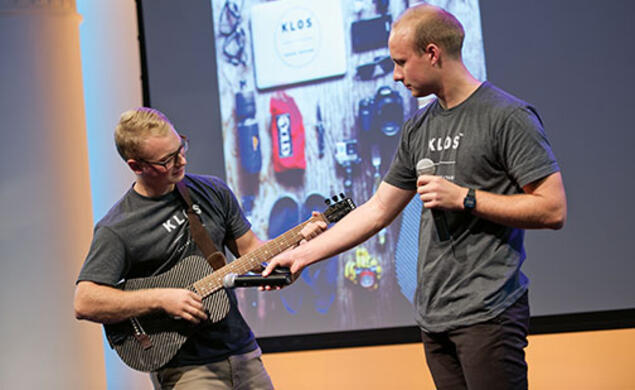 Adam Klosowiak ’15, left, demonstrates a KLOS travel guitar with Jake Sheffield, also of KLOS.