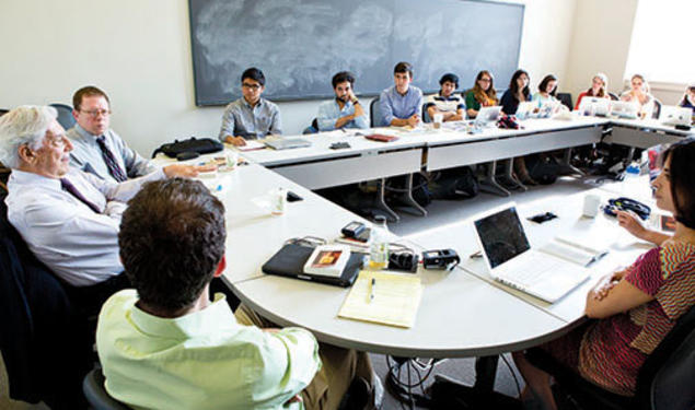 Students listen to Peruvian author Mario Vargas Llosa, left, during a seminar on his writings.