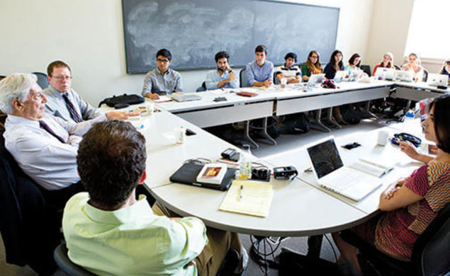 Students listen to Peruvian author Mario Vargas Llosa, left, during a seminar on his writings.