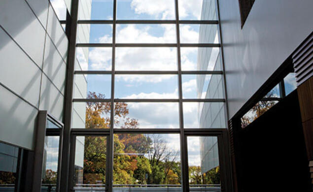 The view south from the two-story atrium of the neuroscience/psychology building; an outdoor patio is beyond the glass wall.