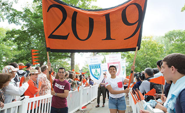 Josh Faires ’19 and Victoria Davidjohn ’19 carry the banner for the Pre-rade as the class is welcomed by other students and alumni.