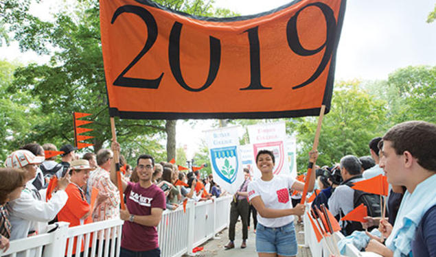 Josh Faires ’19 and Victoria Davidjohn ’19 carry the banner for the Pre-rade as the class is welcomed by other students and alumni.