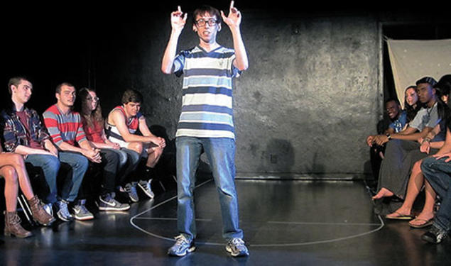 Patrick Roche ’14 performs on campus in 2013 as Ellipses Slam Team members look on.