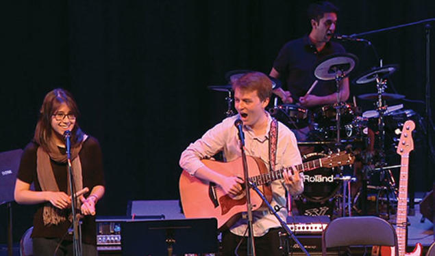 Performing “Death by Mall” during a concert by student songwriters are, from left, Sydney King ’17, Charlie Baker ’17, and Arjun Dube ’15 on drums.