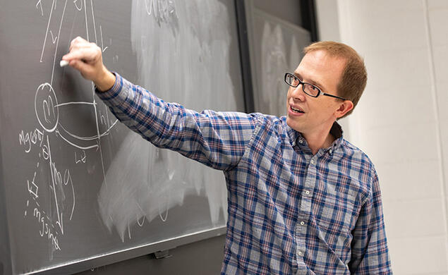 OTC_Andrew Houck.jpg Andrew Houck draws on a blackboard with white chalk.