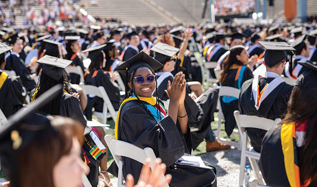 Graduate clapping in crowd