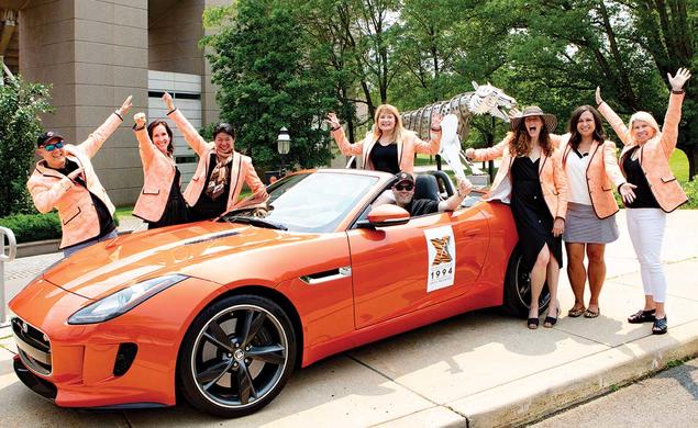 Photo of alumni with orange sports car