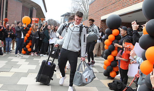 Students cheer for the men’s basketball players as they hit the road for Louisville, Kentucky, where they’ll play Creighton in the NCAA Sweet 16.