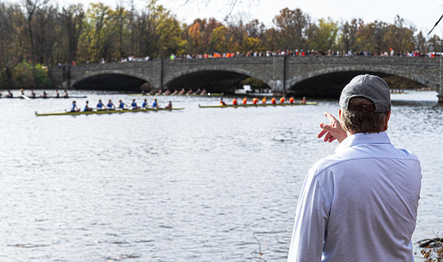 The photo shows Lake Carnegie with rowers in several shells.