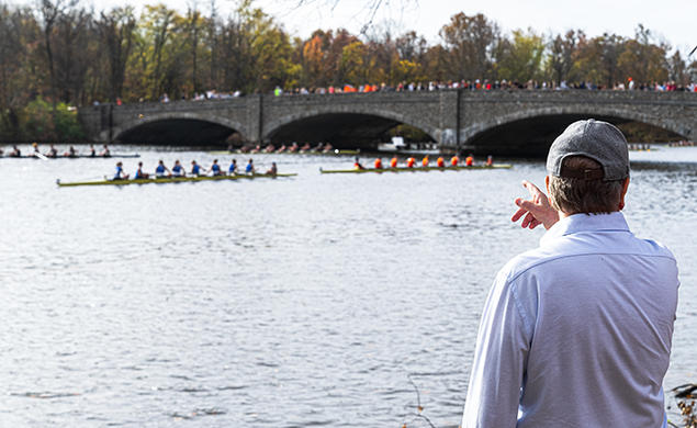 The photo shows Lake Carnegie with rowers in several shells.