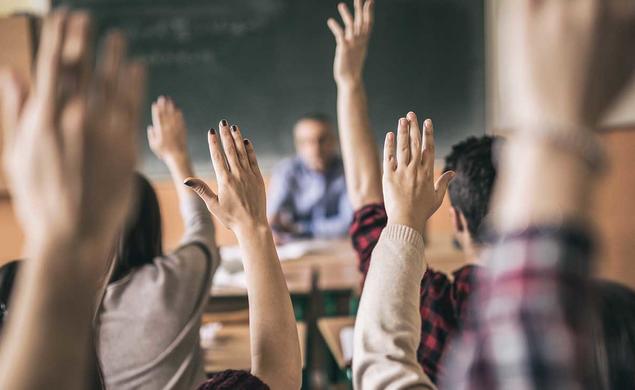 Photo of hands raised in a classroom