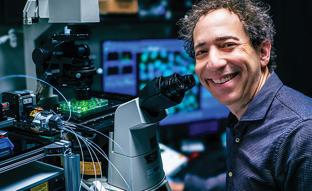 Michael B. Elowitz *99 with a microscope.