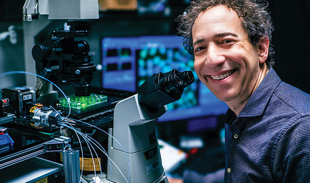 Michael B. Elowitz *99 with a microscope.