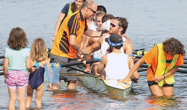 Coach Greg Hughes ’96 congratulates the men’s heavyweight varsity eight.