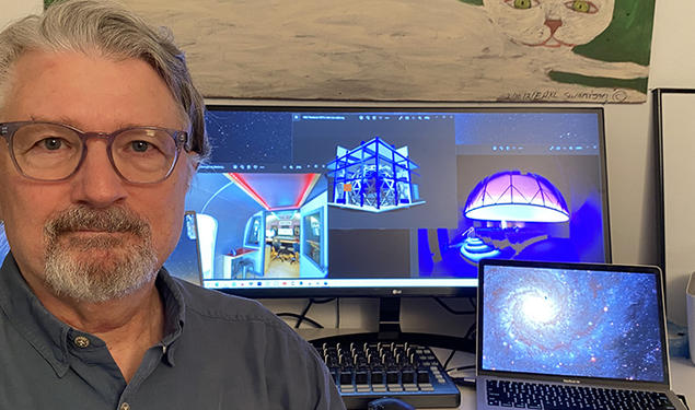 This is a photo of Dave Pentecost in front of the computer screens where he's working on the planetarium.