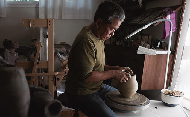 Hideo Mabuchi makes a vase on his pottery wheel.