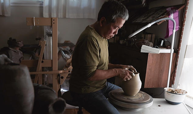 Hideo Mabuchi makes a vase on his pottery wheel.