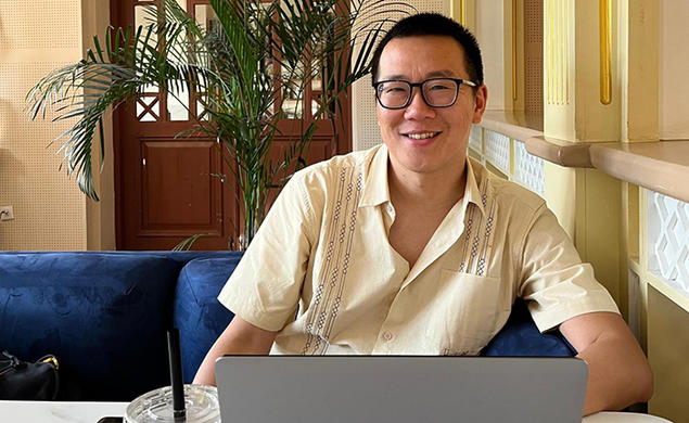 Jonathan Cheng ’05 smiles up from his laptop computer.